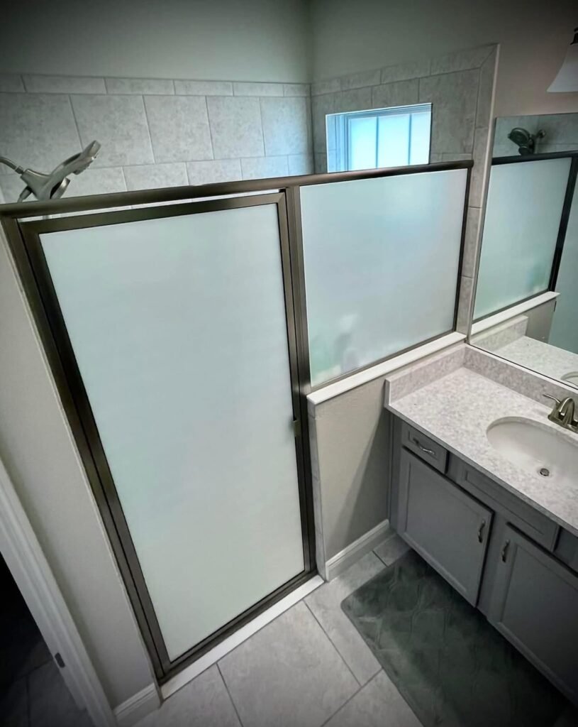 Frosted privacy film on a glass shower enclosure installed by K&H Window Tinting